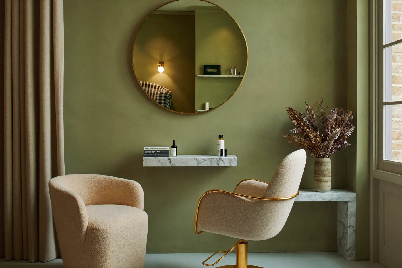 Beauty studio with brass mirror and sage green wall